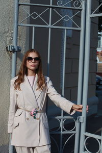 Portrait of female model standing against gate