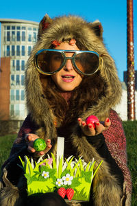 Portrait of young woman wearing large sunglasses at park