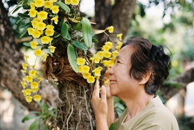 Portrait of woman by yellow flowering plants