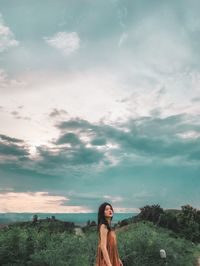 Portrait of woman standing against sky