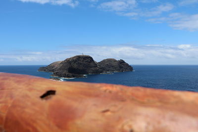 Rock formation in sea against sky