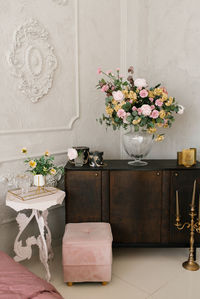 Classic bedroom interior. a brown wooden chest of drawers, flowers in a glass vase