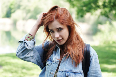 Portrait of young woman standing against plants