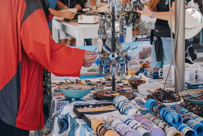 Tourists browsing souvenirs at the market stalls in ana mera, mykonos, greece.