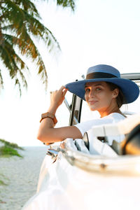 Side view of woman sitting on beach