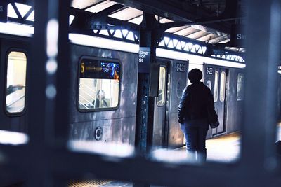 Rear view of man standing at railroad station