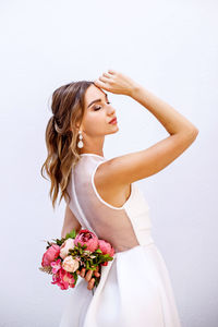 Woman with pink flower against white background