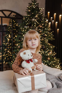 Portrait of cute girl playing with christmas tree