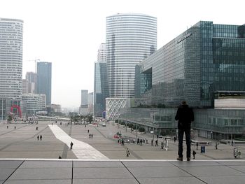 People walking on road along buildings