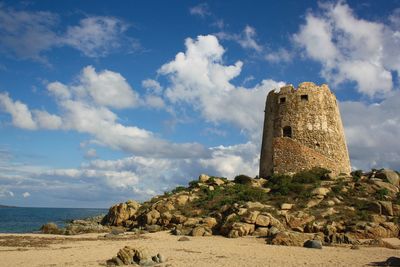 Tower by sea against sky