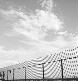 Fence against cloudy sky