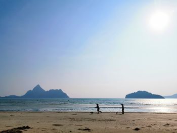 People at beach against sky