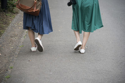 Low section of women walking on footpath