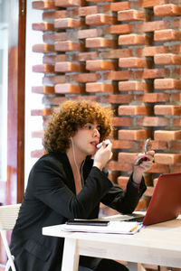 Side view of businesswoman using laptop at table