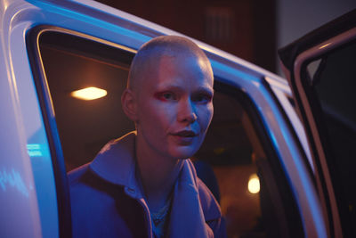 Portrait of young woman with shaved head looking at camera