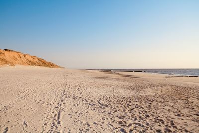 Surface level of beach against clear sky