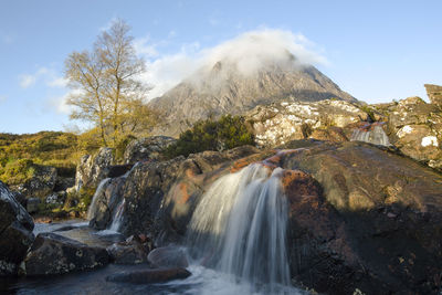 Scenic view of waterfall against sky