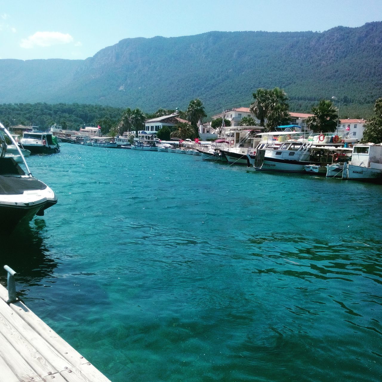 water, nautical vessel, transportation, mountain, boat, mode of transport, moored, sea, sky, scenics, tranquil scene, built structure, tranquility, nature, harbor, mountain range, beauty in nature, tree, lake, river