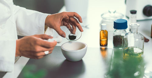 Cropped image of female chef preparing food in commercial kitchen