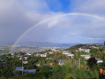 Rainbow over city buildings against sky