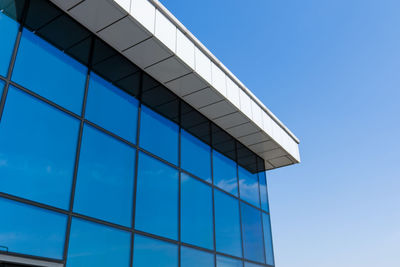 Low angle view of modern building against clear blue sky