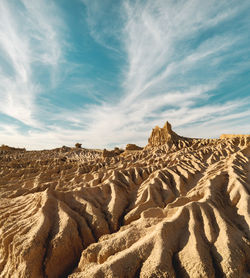 Iconic eroded sand rock formation with dramatic cloud formation in the sky