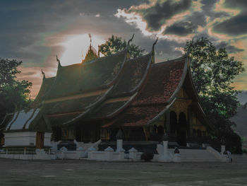Traditional building against sky at sunset