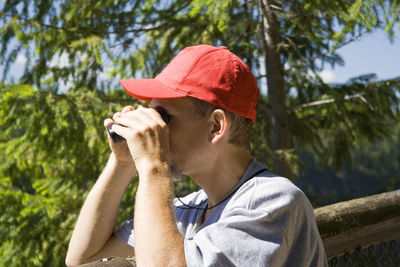 Close-up of man looking through binoculars