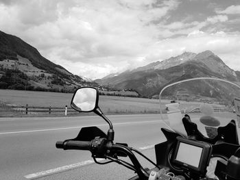 Bicycles on road by mountains against sky