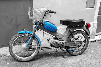 Bicycle parked on street against wall