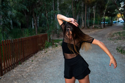 Full length of woman standing on footpath