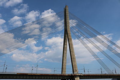 Low angle view of suspension bridge against blue sky