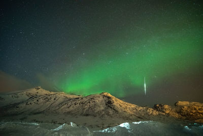 Scenic view of snowcapped mountains against sky at night