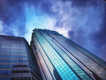 Low angle view of modern building against cloudy sky