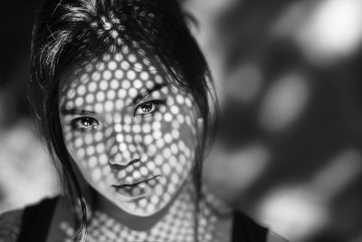 Close-up portrait of woman with shadow on face