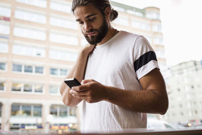 Man using smart phone while walking in city