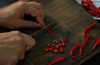 Midsection of person holding red chili peppers