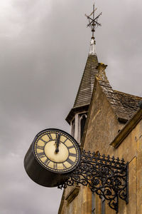 Low angle view of clock tower amidst buildings against sky