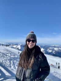 Young woman standing on snow covered landscape enjoying a winter day out 