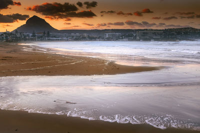 Scenic view of beach against sky during sunset