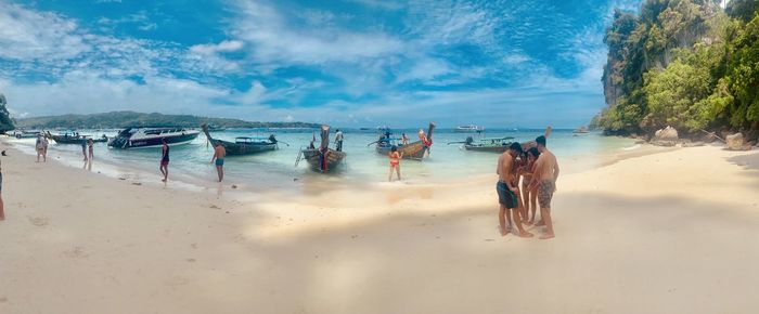 People at beach against sky