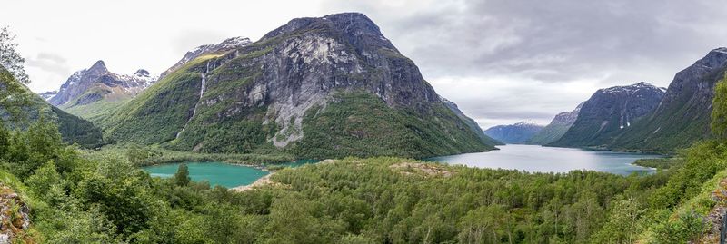 Scenic view of lake by mountains against sky