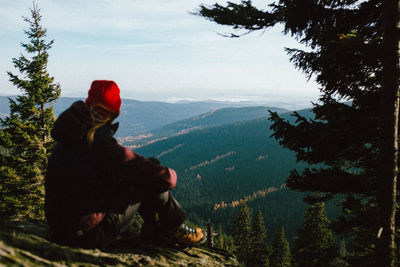Man by plants against mountain range