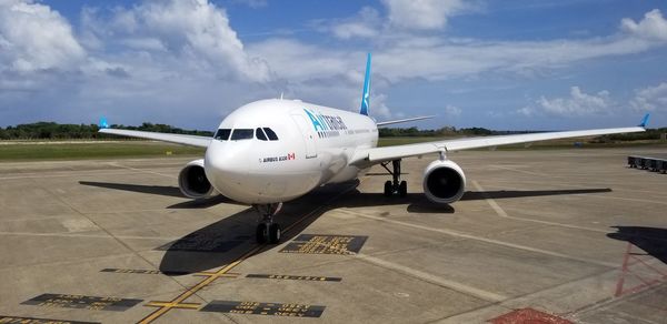 Airplane on runway against sky