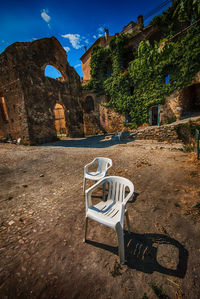 Empty table and chairs against sky