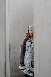 Young man standing against wall