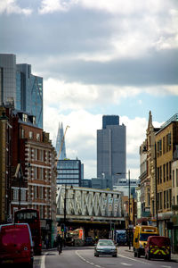 Cars on street in city against sky