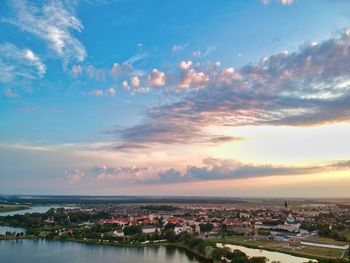 Aerial view of city by sea against sky