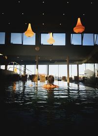 Rear view of man swimming in pool