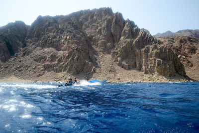 Scenic view of sea and mountains against sky